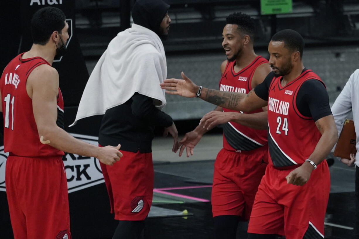 Portland Trail Blazers forward Norman Powell (24) and guard CJ McCollum, second from right, celebrate their win against the San Antonio Spurs with teammates Enes Kanter (11) and Carmelo Anthony, second from left, during the second half of an NBA basketball game in San Antonio, Friday, April 16, 2021.