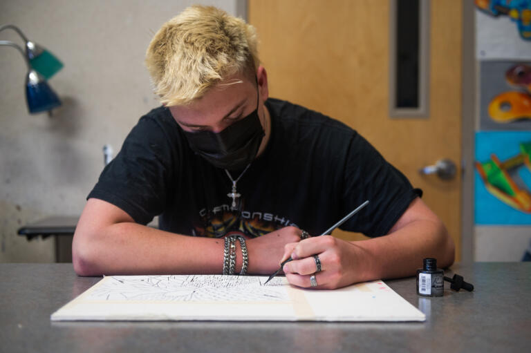 James Hatch works on a mixed media art piece in a class called ÔEverything in ArtÕ, taught by Rod Raunig, at Camas High School on Monday, April 19, 2021. Camas returned to four-day-a-week in-person instruction on Monday.