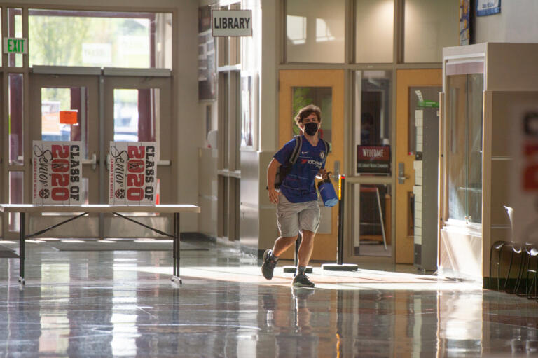 A student runs to class at Camas High School on Monday, April 19, 2021. Camas returned to four-day-a-week in-person instruction on Monday.