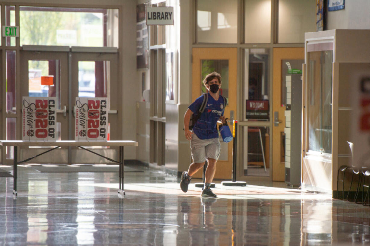 A student runs to class at Camas High School earlier this month after the district switched to in-person instruction four days a week. Officials said there has been no COVID-19 transmission in schools since the change.