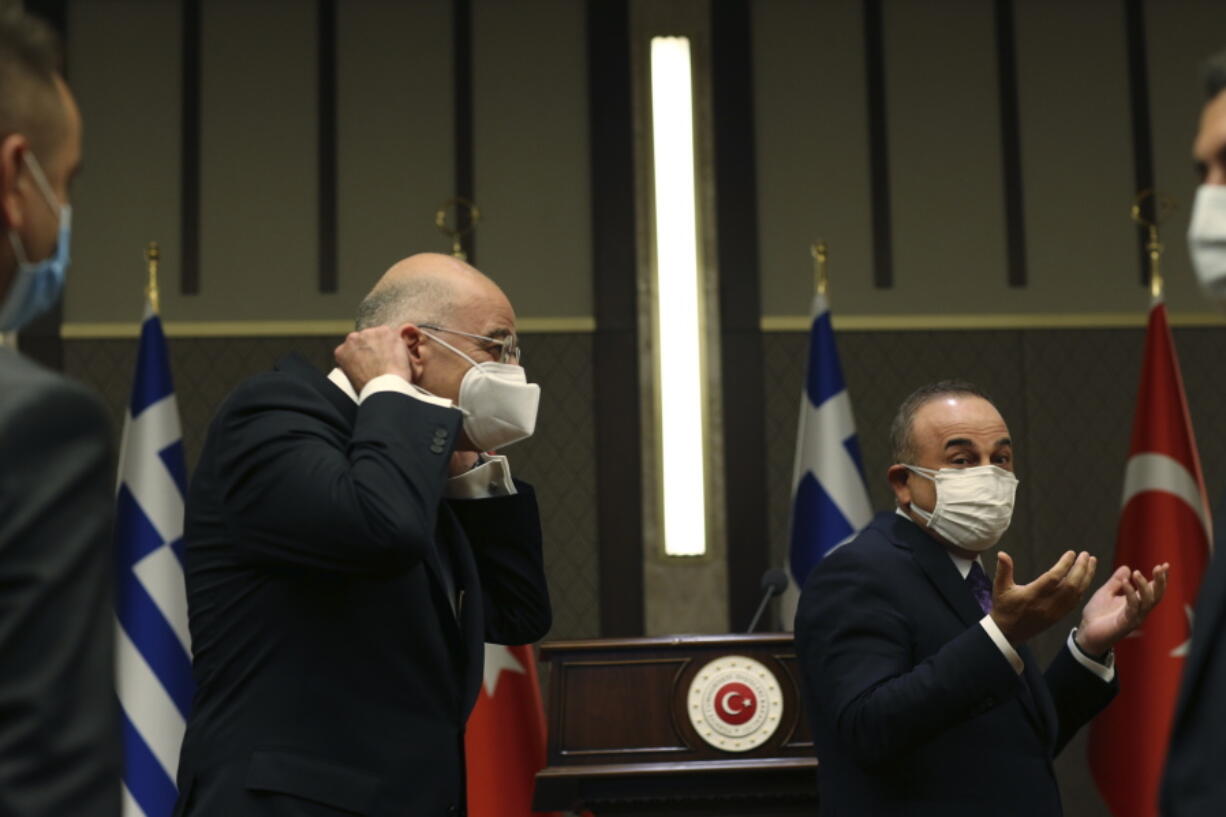 Turkish Foreign Minister Mevlut Cavusoglu, right, walks with Greek Foreign Minister Nikos Dendias, left following their joint media statement after their meeting in Ankara, Turkey, Thursday, April 15, 2021. Dendias travelled to Ankara for talks on the two NATO allies' fraught relationship, following a slight easing of tensions between the neighbors. The visit is the first between the two nations following a tumultuous year.