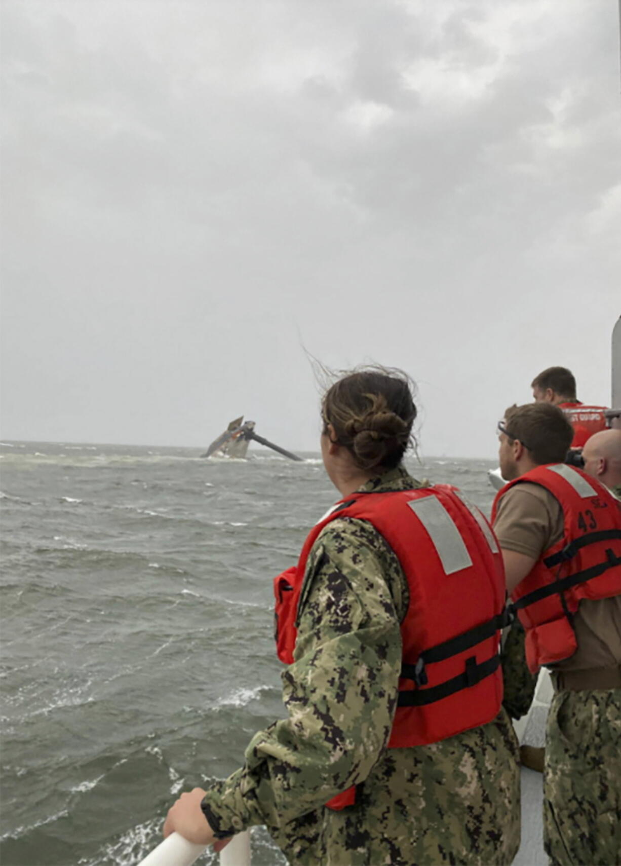 In this photo provided by the U.S. Coast Guard, crew members of the Coast Guard Cutter Glenn Harris scan the water while searching for those missing Tuesday, April 13, 2021, after a 175-foot commercial lift boat capsized 8 miles south of Grand Isle, La. The Seacor Power, an oil industry vessel, flipped over Tuesday in a microburst of dangerous wind and high seas. (U.S.