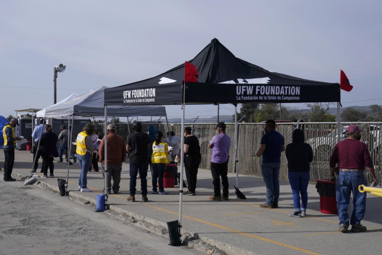 FILE - In this March 3, 2021, file photo, farmworkers wait in line to receive the Moderna COVID-19 vaccine at a County of Santa Clara mobile vaccination clinic at Monterey Mushrooms, an agricultural employer under the United Farm Workers union contract, in Morgan Hill, Calif.