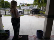 Nicole Russell looks out from her porch, Friday, March 12, 2021, in Kendall, Fla. Because of the pandemic, Nicole because fearful of leaving her home and retreated to her bedroom for days at a time. While some felt restricted by the confinement of home &quot;caves&quot;, others found a sense of safety and comfort, becoming increasingly accustomed to the isolation.