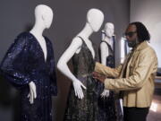 Fashion designer Kevan Hall pauses for a picture with his "Galaxy Collection" at his haute couture atelier in West Los Angeles Thursday, March 18, 2021. A year ago, Hall quickly moved away from his trademark gowns and cocktail dresses to caftans, tunics and pull-on pants. Now Hall is adding back some dressier looks, but he's eliminating the full skirts and scaling back the beading in favor of simple gowns and dresses in knit and tulle fabrics.