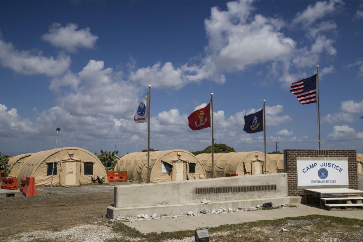 FILE - In this April 18, 2019, file photo, in this photo reviewed by U.S. military officials, flags fly in front of the tents of Camp Justice in Guantanamo Bay Naval Base, Cuba.