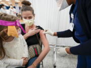 Mosque member Asie Late&#039;s granddaughter Emma watches as a Northwell Health registered nurse inoculates her with the Johnson &amp; Johnson COVID-19 vaccine at a pop up vaccination site inside the Albanian Islamic Cultural Center, Thursday, April 8, 2021, in the Staten Island borough of New York.