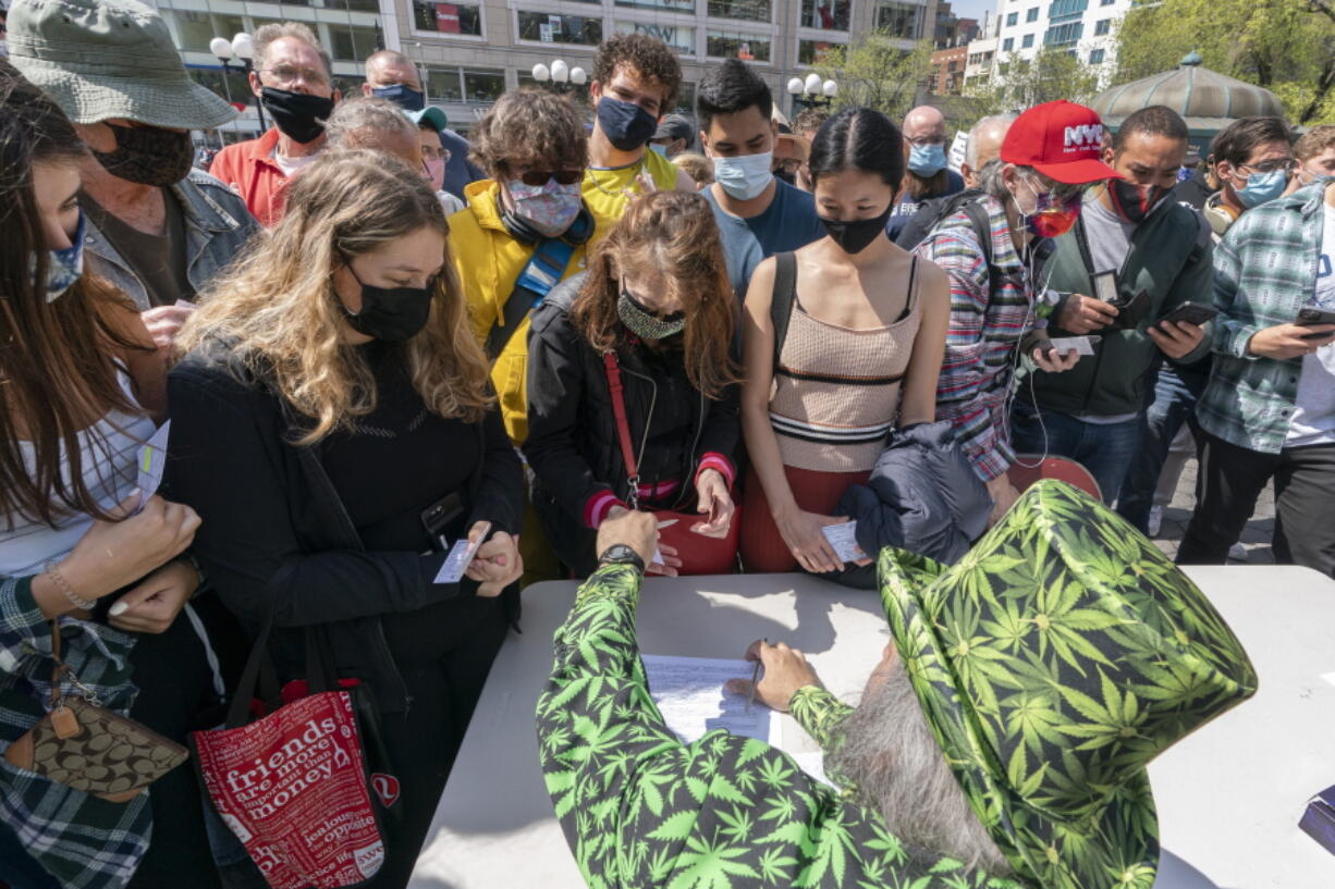 FILE - In this Tuesday, April 20, 2021, file photo, a man wearing a cannabis costume hands out marijuana cigarettes in New York during a "Joints for Jabs" event, where adults who showed their COVID-19 vaccination cards received a free joint. Free beer, pot and doughnuts. Savings bonds. A raffle ticket for a snowmobile. Places around the U.S. are offering incentives to try to energize the nation's slowing vaccination drive and get reluctant Americans to roll up their sleeves.