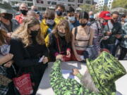 FILE - In this Tuesday, April 20, 2021, file photo, a man wearing a cannabis costume hands out marijuana cigarettes in New York during a "Joints for Jabs" event, where adults who showed their COVID-19 vaccination cards received a free joint. Free beer, pot and doughnuts. Savings bonds. A raffle ticket for a snowmobile. Places around the U.S. are offering incentives to try to energize the nation's slowing vaccination drive and get reluctant Americans to roll up their sleeves.