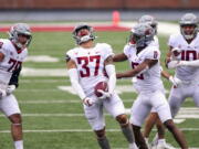 Washington State linebacker Justus Rogers (37) celebrates with with defensive back Jaylen Watson (0) and others after intercepting a pass by quarterback Jarrett Guarantano during the first quarter of the NCAA college football team's spring game Saturday, April 24, 2021, in Pullman, Wash.