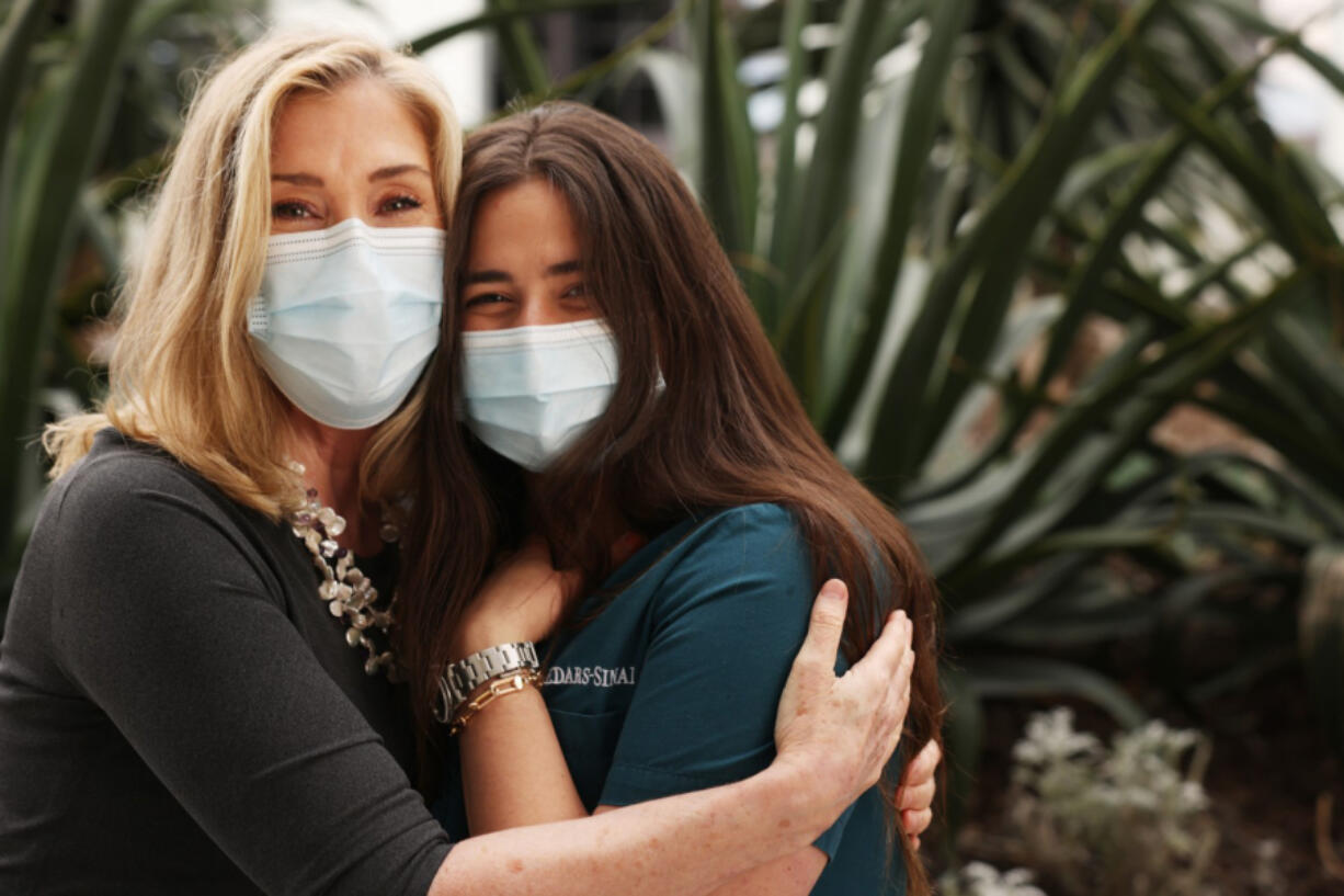 Peggy Kelley, left, a Protestant Christian chaplain stands with Jillian Katz, an Orthodox Jewish nurse on Cedars-Sinai's COVID-19 unit, in the Healing Gardens on March 12 in Los Angeles, Calif. Usually, chaplains focus on providing spiritual care for patients and their families but since the pandemic, health care staff like Katz, have been needing them more.