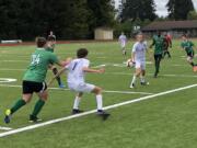 Columbia River's Alexander Harris (7) shields off a Tumwater defender after a pass from teammate Logan Simmons (9) during the 2A boys soccer district championship match on Saturday at Tumwater High School.