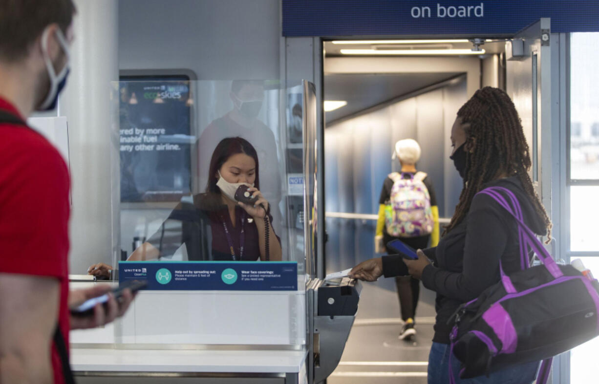 United Airlines gate agent Emma Watt helps passengers scan their boarding passes for a flight to San Francisco at O'Hare International Airport on June 18.