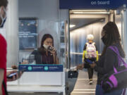 United Airlines gate agent Emma Watt helps passengers scan their boarding passes for a flight to San Francisco at O'Hare International Airport on June 18.