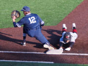 Skyview first baseman Brock Blakley (12) takes a throw as Camas baserunner Zach Blair safely dives back to the bag.