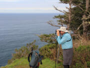 Jim Border scans the horizon for signs of whale spouts from the tip of Cape Lookout, near Tillamook, Ore., in March 2015. The trail along the north Oregon Coast is reopening after being closed more than eight months due to storm damage.