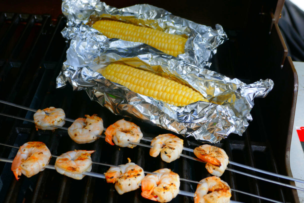 Grilled shrimp kabobs and grilled corn on the cob.