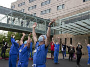 Amanda Cowan/The Columbian 
 Dr. Pierre Provost, an anesthesiologist at Legacy Salmon Creek Medical Center, joins colleagues and hospital staff as they greet members of the Oregon Air National Guard as they fly two F-15 Eagles over the area on Friday morning, May 22, 2020 as a tribute to front-line workers during the pandemic.