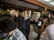 Usher Antoine Soumakian takes parishioners temperatures as they file in for Sunday service at Our Lady Queen of Martyrs Church, an Armenian church on Sunday, April 25, 2021 in Boyle Heights, CA.