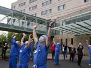 Dr. Pierre Provost, an anesthesiologist at Legacy Salmon Creek Medical Center, joins colleagues and hospital staff as they greet members of the Oregon Air National Guard as they fly two F-15 Eagles over the area on Friday morning, May 22, 2020. Amanda Cowan won a first place Society for Professional Journalists award for the photo.