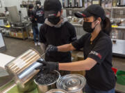 Sharetea owner NaNa Sisakvanich, right, combines vats of black tapioca pearls while Tyme Sisakvanich watches at Sharetea in Hazel Dell. A global shortage in the ingredients that make up the tapioca pearls in boba tea is affecting businesses that serve the colorful drinks.