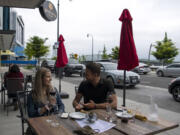 Seattle residents Becca Roundhill and Dominic Thibodeau enjoy red wine on an overcast April evening at Brian Carter Cellars at The Waterfront Vancouver. Getting a spot with a river view takes some planning.