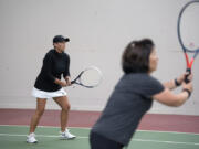 Jill Watson, left, who hosts a tennis tournament Alzheimer's fundraiser in the spring each year, joins Delena Palena as they take on opponents at Club Green Meadows in Vancouver.