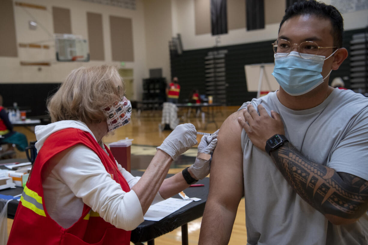 Medical Reserve Corps volunteer Ruth Gorley gives Vancouver resident Ryan Tydingco a Johnson & Johnson COVID-19 vaccine May 8 at Clark County Public Health's short-term vaccination pod at Woodland High School. After an early rush of people, the flow had slowed down by the late morning for the drop-in vaccination event.