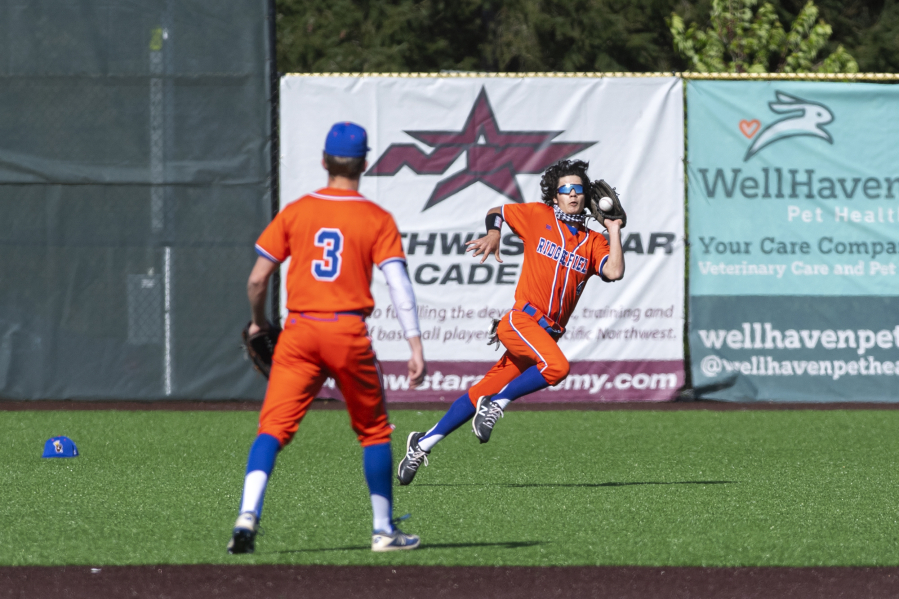 Ridgefield center fielder Reed Fry can'it quite corral a fly ball in the first inning on Tuesday, May 4, 2021, at the Ridgefield Outdoor Recreation Complex. Columbia River won 4-2 to advance in the 2A Southwest District Tournament.