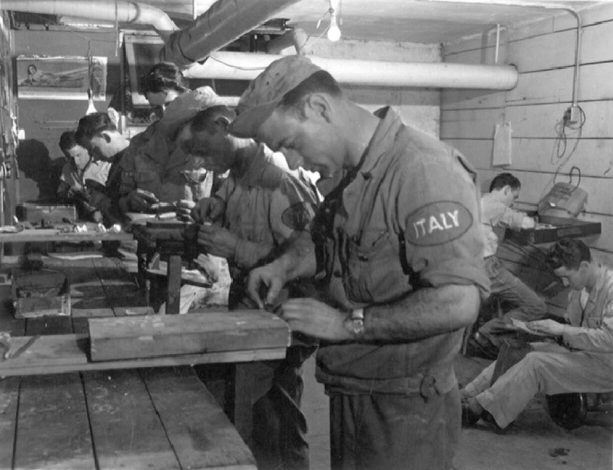 After Italy's surrender in 1943, the Allies sent Italian prisoners of war to the U.S. Some came to Vancouver to wait out the end of the war. The POWs followed the barracks military schedule and discipline. They wore khaki uniforms with "Italy" patches on the left sleeve. Those with specialized skills put their experience to use for the Army. The rest labored at Vancouver Barracks on anything the military needed. The men in this photo appear to be in a woodworking shop. The POWs stayed until 1946 working at the barracks, Camp Hathaway and Camp Bonneville. (Contributed by U.S.