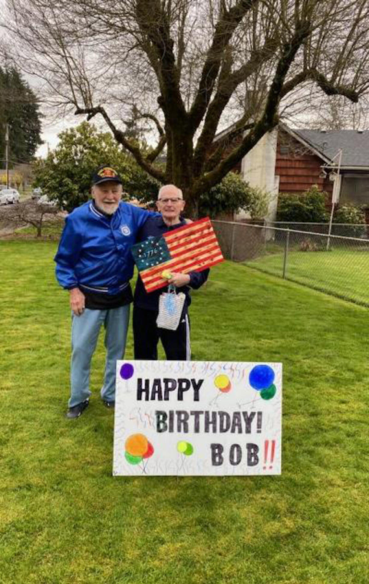 WASHOUGAL: At left is Bob Rodgers with Robert "Bob" Peake, holding the wooden flag that was presented to Peake on his 90th birthday by the Patriot Guard.