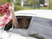 In the back of a limo with a sparkling drink in hand, Kylie Dombrowsky celebrates receiving her bachelor's degree in business administration Saturday during the drive-through graduation ceremony for Washington State University Vancouver. "If we're going to celebrate during COVID, we're going to celebrate right," an elated Dombrowsky said.