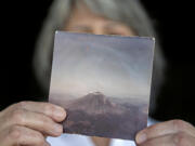 Jaquie Cole of Ridgefield displays a photo she took of Mount St. Helens in 1980 on Monday afternoon, May 10, 2021. Cole and her friend flew in a small plane over Mount St. Helens on the afternoon of May 17, 1980, less than 24 hours before the big eruption.