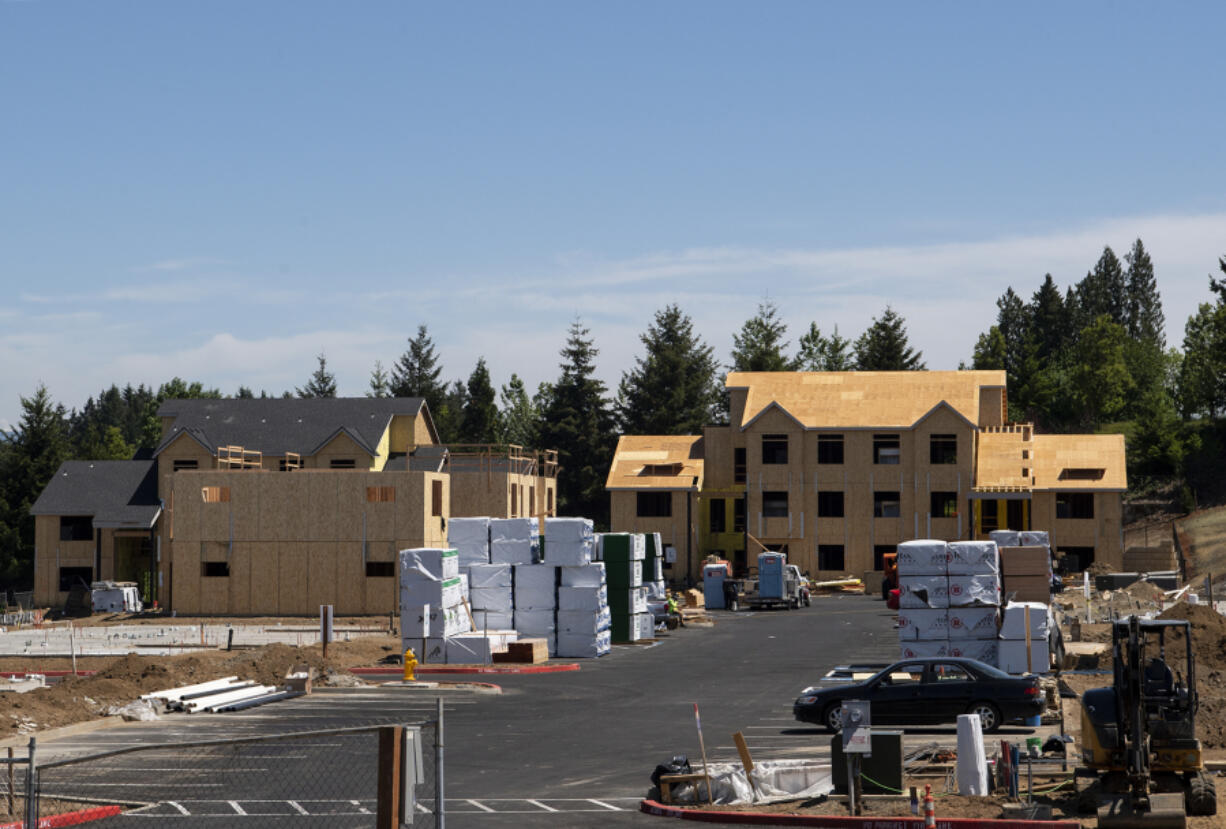 Stacks of lumber sit on the lot ready to be used to construct apartment buildings on Friday at the Latitude 45 apartment complex in Vancouver. Local builders have had to navigate rising lumber prices amid a national spike in demand.