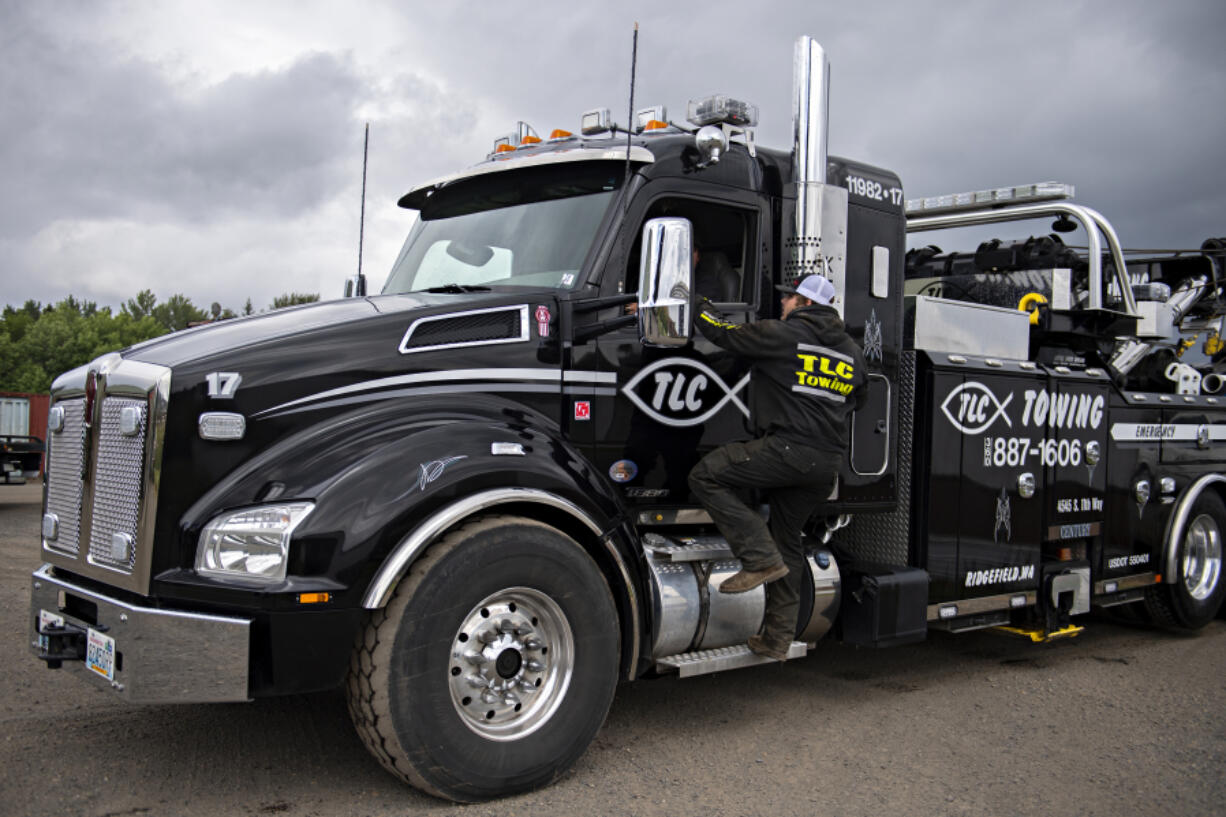 Logan Wells of TLC Towing talks with a colleague at TLC Towing on a recent weekday. The business employs 20 people and is always looking to hire more drivers.