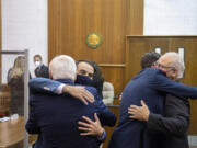 Attorney Evan Bariault. Facing from left, congratulates Don Benton as fellow attorney Mark Conrad supports Christopher Clifford after the jury ruled in their favor at the conclusion the lawsuit trial at the Clark County Courthouse on Thursday morning, May 20, 2021.