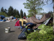 A worker removes garbage from a homeless encampment in northeast Vancouver on Thursday morning, April 29, 2021. Vancouver's new homeless resources coordinator is presenting her strategy for supported camp sites.