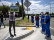 Protesters with opposite points of view on COVID-19 vaccination face off outside Ridgefield High School on Wednesday. Students at the high school helped organize a vaccination clinic in their school's gym.