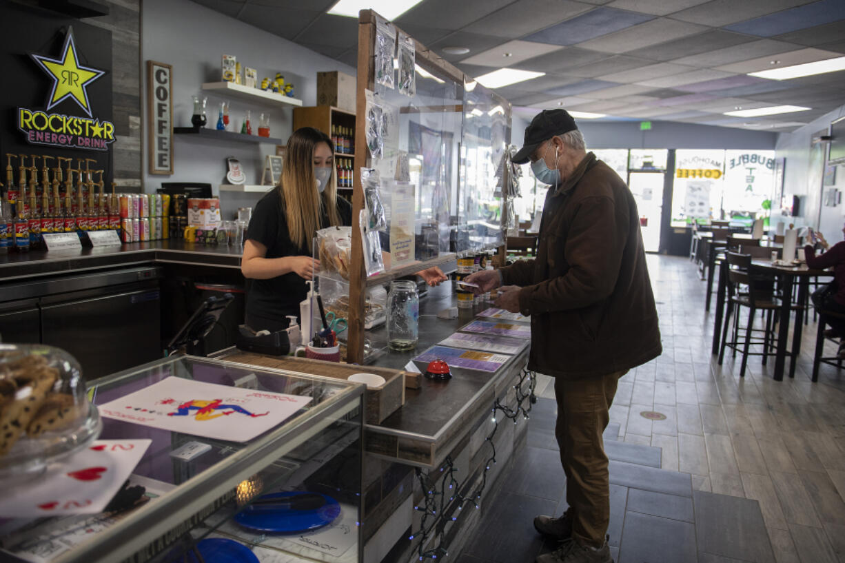 Alisha Heilman serves customer Roger Keast of Vancouver on Friday morning at Madhouse Coffee in Vancouver.