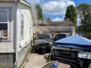 Clark-Cowlitz Fire Rescue crews make entry Tuesday afternoon into an attached garage on fire in Woodland. A small pet dog was found dead inside. The family was not home at the time of the blaze. The cause of the fire remains under investigation, according to the fire agency.