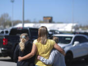 People embrace outside after a shooting at Rigby Middle School in Rigby, Idaho on Thursday, May 6, 2021.  Authorities say a shooting at the eastern Idaho middle school has injured two students and a custodian, and a male student has been taken into custody.