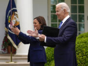 President Joe Biden claps with Vice President Kamala Harris after speaking on updated guidance on face mask mandates and COVID-19 response, in the Rose Garden of the White House, Thursday, May 13, 2021, in Washington.