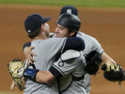 New York Yankees starting pitcher Corey Kluber, catcher Kyle Higashioka, right, and first baseman Luke Voit, rear, celebrate after Kluber threw a no-hitter against the Texas Rangers in a baseball game in Arlington, Texas, Wednesday, May 19, 2021.