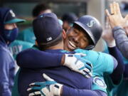 Seattle Mariners' Kyle Lewis is embraced by a teammate after his two-run home run against the Texas Rangers during the third inning of a baseball game Friday, May 28, 2021, in Seattle.