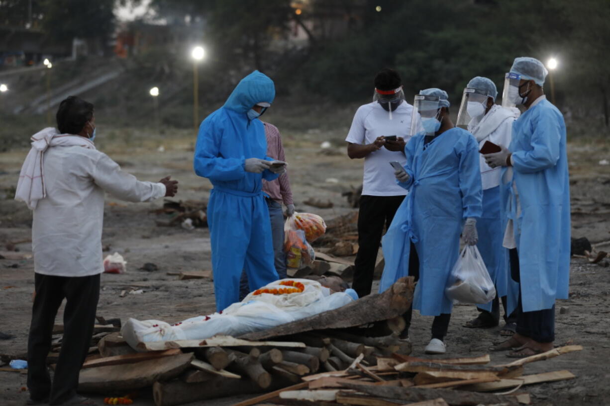 Family members pay last respect to their relative Rajendra Prasad Mishra, a 62-year-old man who has lost his life from coronavirus infection before cremation at River Ganges at Phaphamau in Prayagraj, India, Saturday, May 8, 2021.