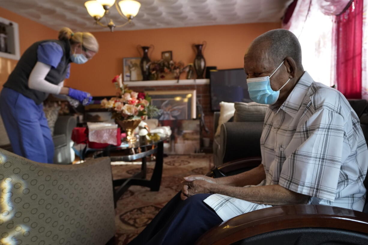 Edouard Joseph, 91, right, waits Feb. 11 as geriatrician Megan Young prepares to give him a COVID-19 vaccination at his home in the Mattapan neighborhood of Boston. A majority of Americans agree that government should help people age in their own homes, not institutional settings, according to a new survey from The Associated Press-NORC Center for Public Affairs Research.