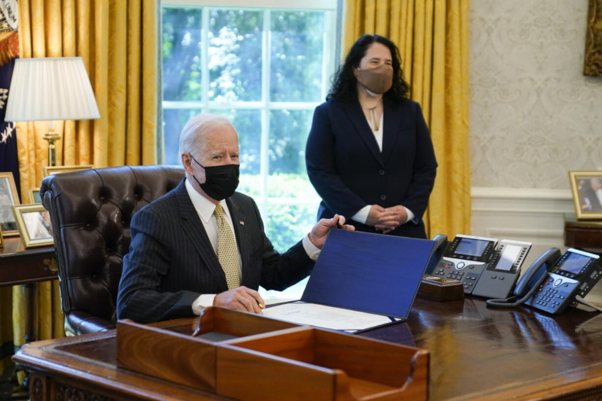 In this March 30, 2021 photo, President Joe Biden signs the PPP Extension Act of 2021, in the Oval Office of the White House in Washington. Small Business Administration administrator Isabel Guzman is at right. Biden is promoting his $28.6 billion program to help the restaurants, bars and food trucks hurt by the coronavirus pandemic.