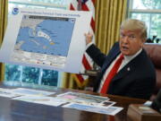 FILE - In this Wednesday, Sept. 4, 2019, file photo, President Donald Trump talks with reporters after receiving a briefing on Hurricane Dorian in the Oval Office of the White House, in Washington. A new 46-person federal scientific integrity task force with members from dozens of government agencies will meet for the first time Friday, May 14, 2021. During Sharpiegate, NOAA reprimanded some meteorologists for tweeting that Alabama was not threatened by the hurricane, contradicting the president, who said Alabama was in danger.