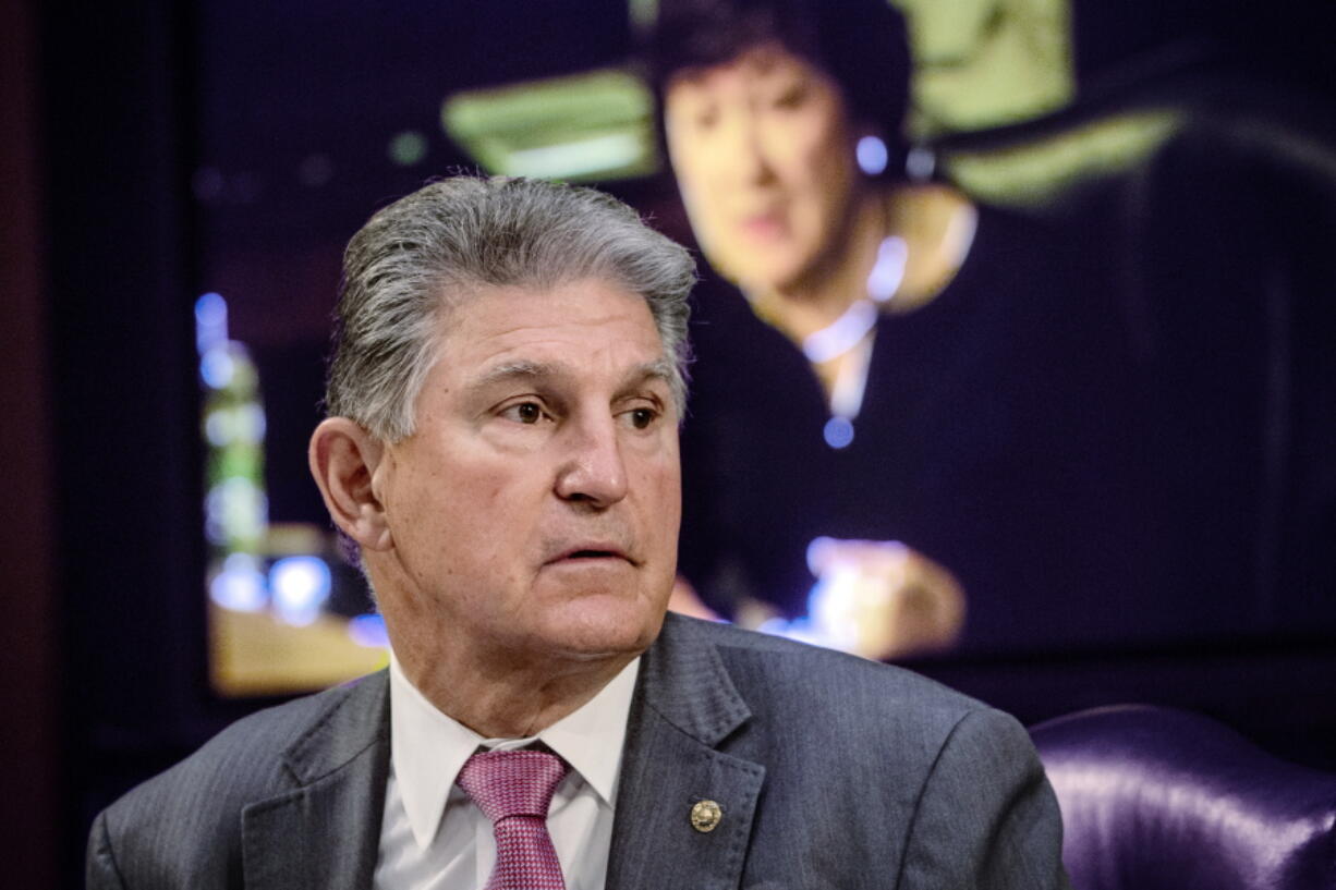 FILE - In this May 12, 2021, file photo, Sen. Joe Manchin, D-W.Va., listens as Sen. Susan Collins, R-Maine, on the monitor behind him, asks questions during a hearing on Capitol Hill in Washington.