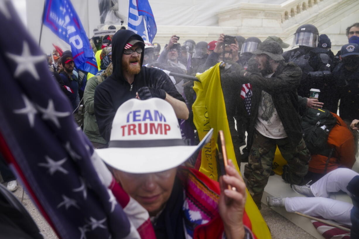 FILE - In this Jan. 6, 2021, file photo, rioters try to break through a police barrier, at the Capitol in Washington.